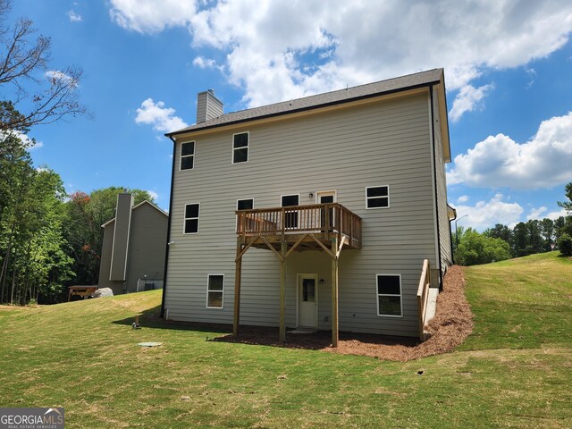 back of house featuring a yard and a wooden deck