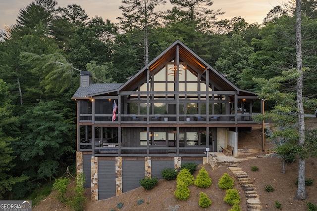 back house at dusk featuring a sunroom