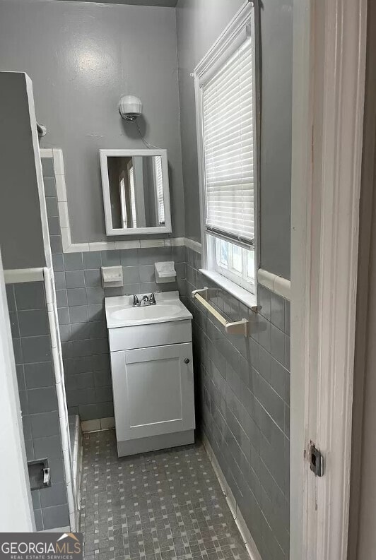 bathroom featuring tile patterned flooring, tile walls, and vanity