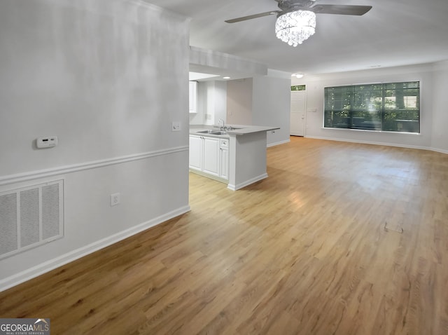 unfurnished living room featuring ceiling fan, sink, and light hardwood / wood-style floors