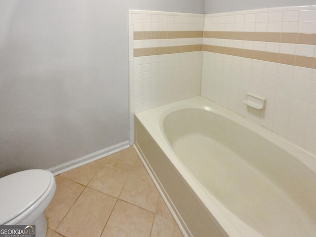 bathroom with tile patterned flooring, a bath, and toilet