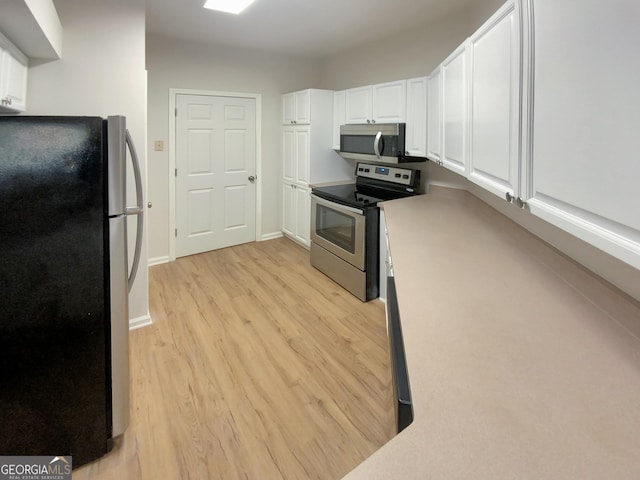 kitchen featuring light wood-type flooring, white cabinetry, and stainless steel appliances