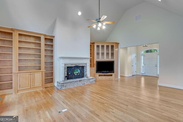 unfurnished living room featuring a brick fireplace, high vaulted ceiling, ceiling fan, and light hardwood / wood-style flooring