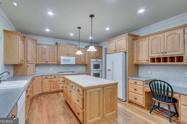 kitchen featuring white appliances, pendant lighting, a center island, crown molding, and sink