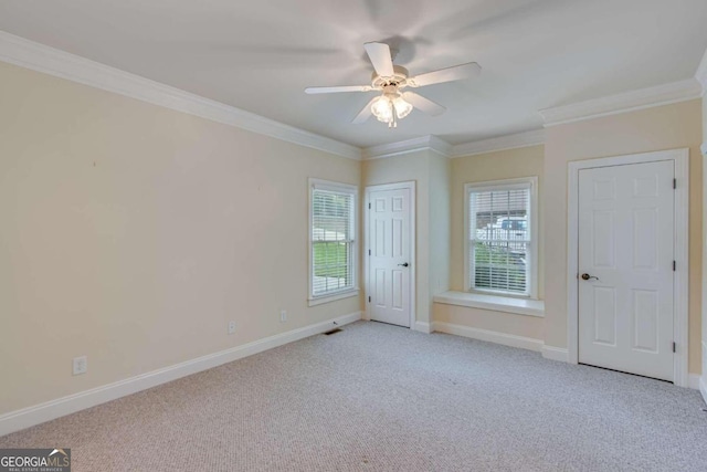 carpeted spare room with ceiling fan and ornamental molding