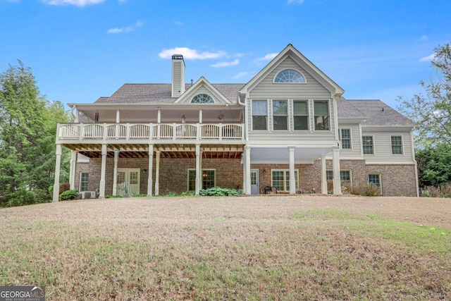 back of property with a deck and a lawn