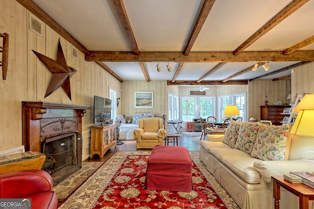 living room with beam ceiling and wooden walls