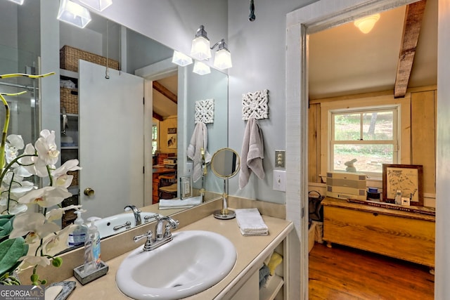 bathroom with vanity, hardwood / wood-style flooring, and beam ceiling