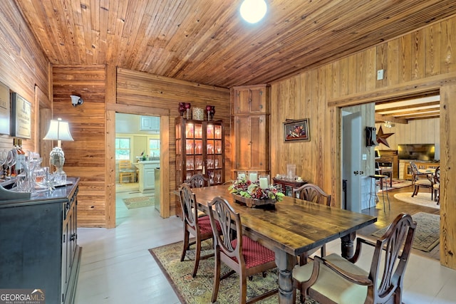 dining space with wood ceiling, wooden walls, and wood-type flooring