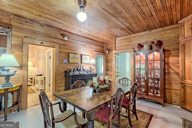 dining space featuring wood ceiling, wood walls, and light wood-type flooring