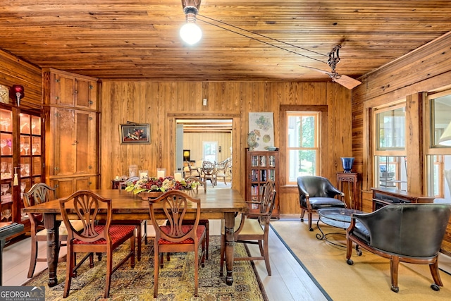 dining area with wood ceiling, ceiling fan, wood walls, and hardwood / wood-style flooring