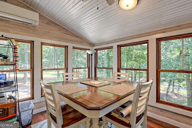 dining area featuring an AC wall unit, dark hardwood / wood-style flooring, lofted ceiling, and a wealth of natural light