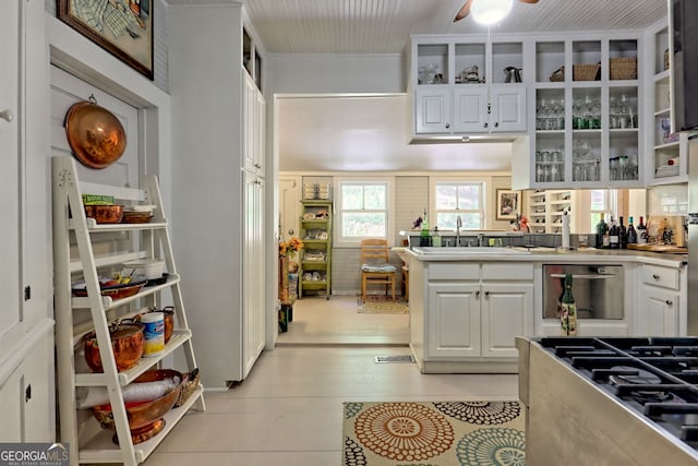 kitchen with white cabinetry, light wood-type flooring, sink, and ceiling fan