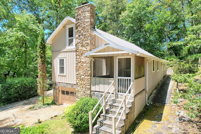 208 Colony Rd, Dillard, GA 30537 - view of front of property featuring an attached garage, board and batten siding, a chimney, and driveway