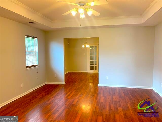 unfurnished room featuring ornamental molding, ceiling fan, a raised ceiling, and hardwood / wood-style floors