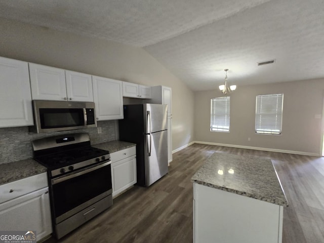 kitchen featuring lofted ceiling, decorative backsplash, white cabinets, dark hardwood / wood-style flooring, and appliances with stainless steel finishes