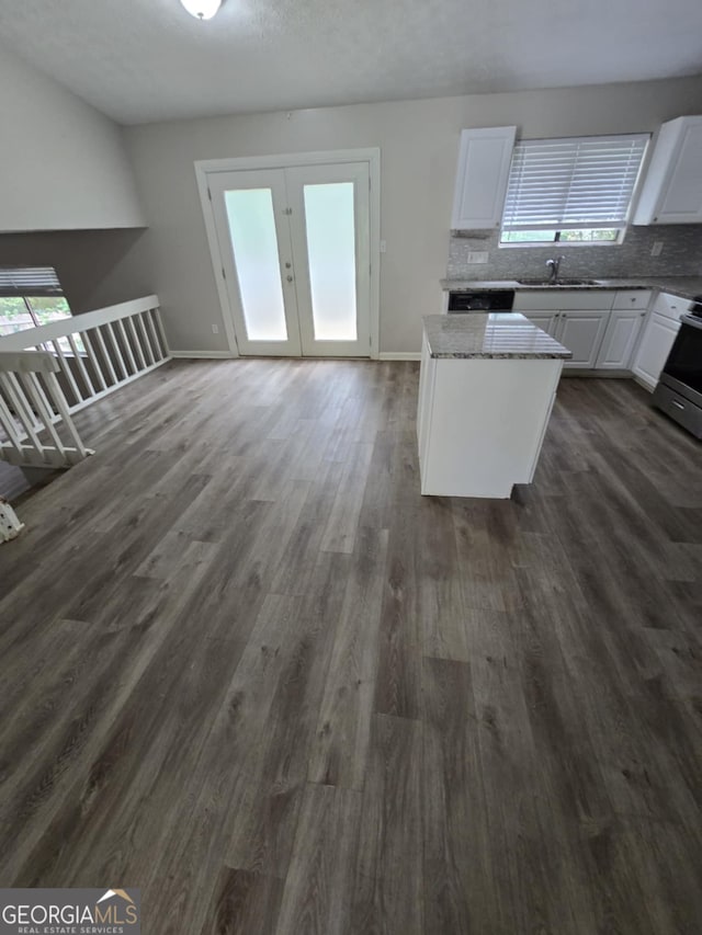 kitchen with dark wood-type flooring, stainless steel range, french doors, and white cabinets