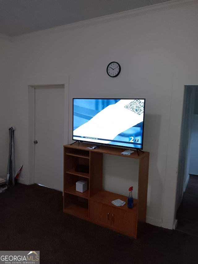 unfurnished living room with crown molding and dark carpet