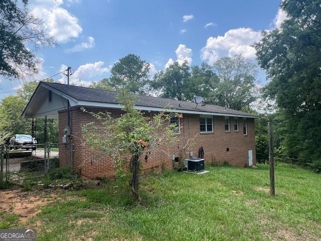 rear view of property featuring a yard and central AC