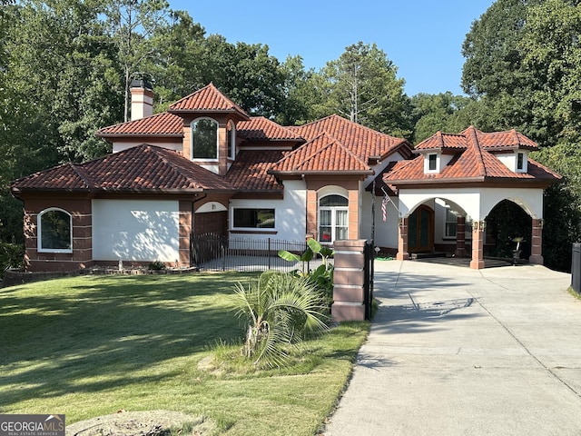 mediterranean / spanish-style house featuring a front lawn and a garage