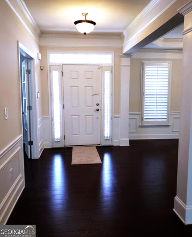 foyer entrance with dark wood-type flooring and crown molding