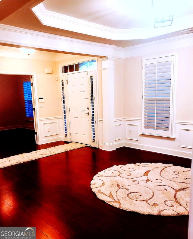 foyer featuring hardwood / wood-style floors, crown molding, and a tray ceiling