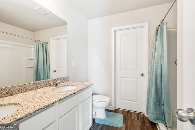 bathroom with walk in shower, hardwood / wood-style floors, vanity, and toilet