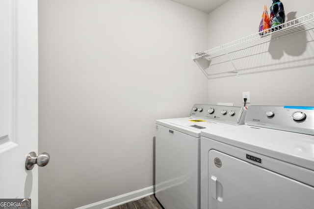 laundry area with dark hardwood / wood-style flooring and washer and clothes dryer