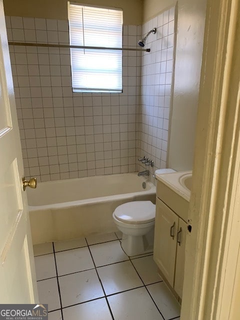 full bathroom with vanity, tile patterned flooring, tiled shower / bath combo, and toilet