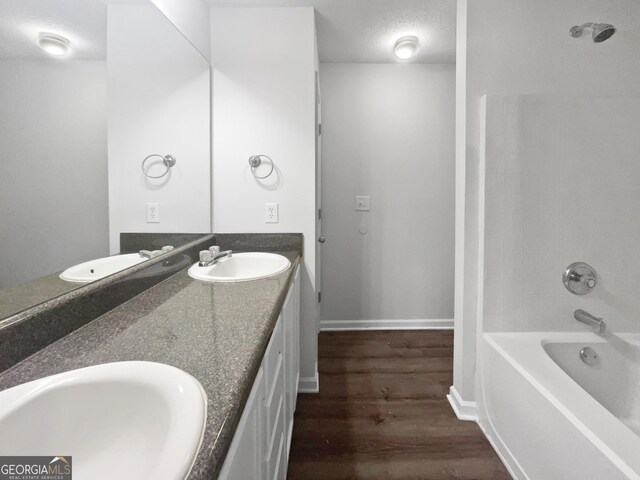 bathroom featuring hardwood / wood-style flooring, vanity, a textured ceiling, and  shower combination