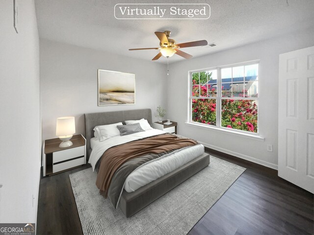 bedroom with ceiling fan, dark hardwood / wood-style floors, and a textured ceiling