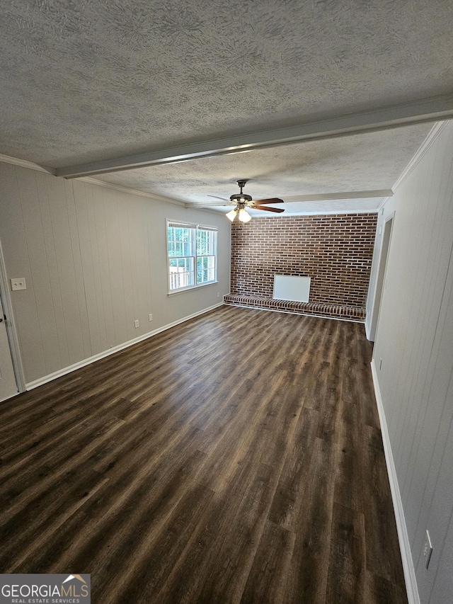 unfurnished living room featuring brick wall, wood walls, ceiling fan, dark wood-type flooring, and a textured ceiling