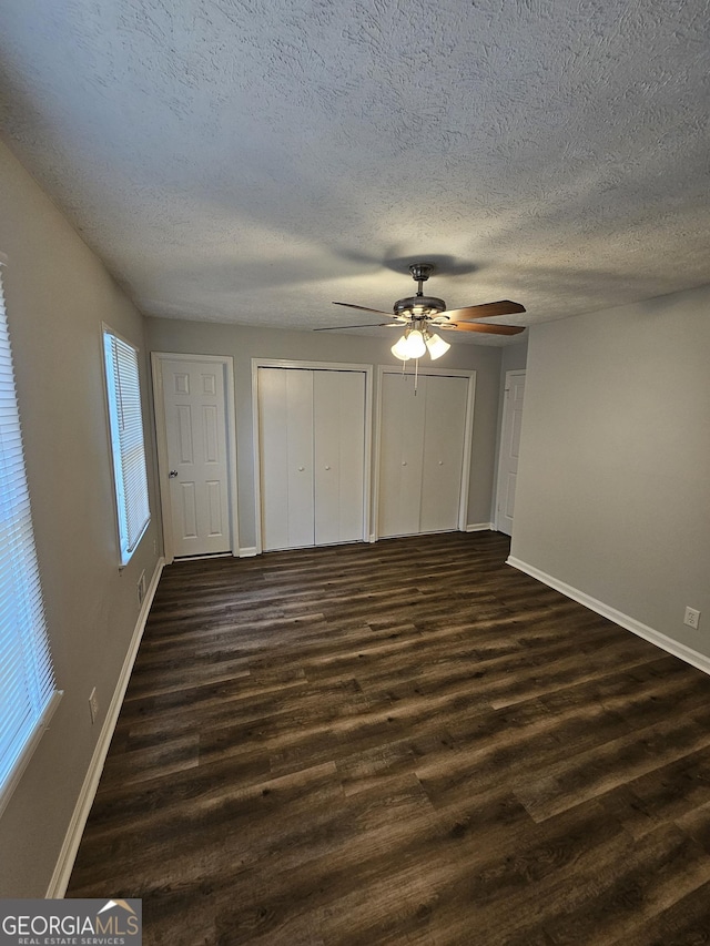 unfurnished bedroom featuring dark hardwood / wood-style flooring and ceiling fan