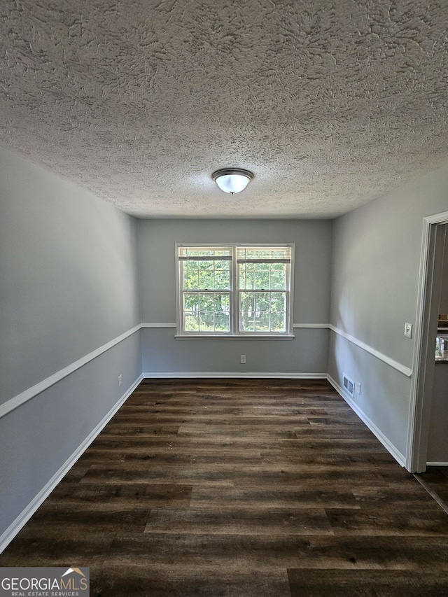 unfurnished room featuring dark hardwood / wood-style floors and a textured ceiling