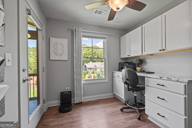 home office featuring ceiling fan, light hardwood / wood-style flooring, and built in desk