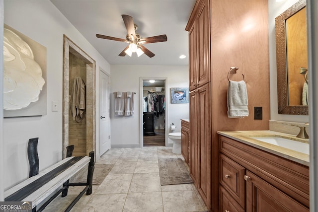 bathroom featuring ceiling fan, tile patterned floors, tiled shower, toilet, and vanity