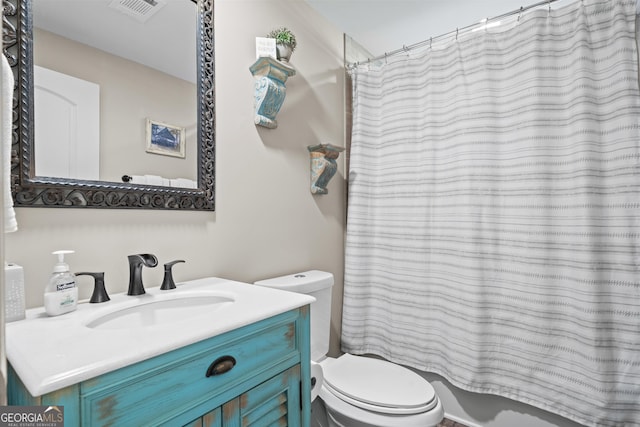 bathroom featuring curtained shower, vanity, and toilet