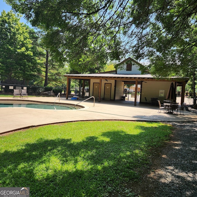 view of pool with ceiling fan, a patio area, and a yard