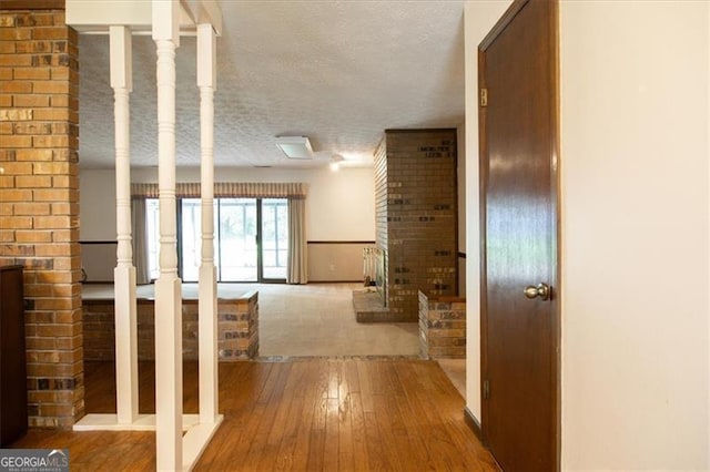 hallway featuring a textured ceiling and hardwood / wood-style floors