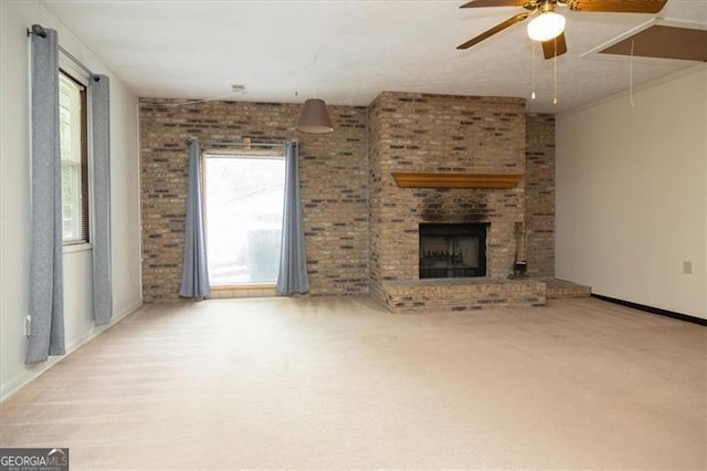 unfurnished living room with a wealth of natural light, ceiling fan, carpet floors, and a fireplace