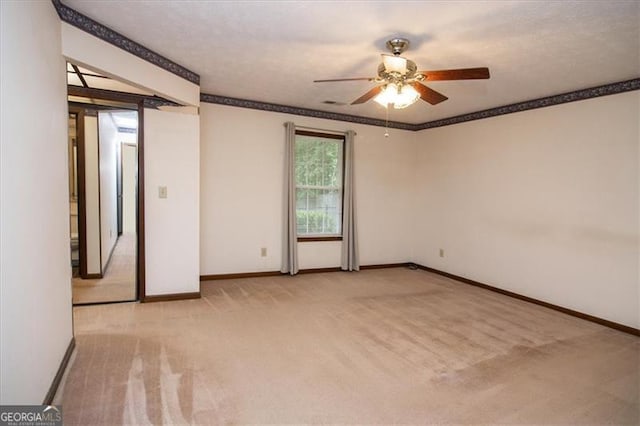 empty room with ceiling fan, light carpet, and ornamental molding