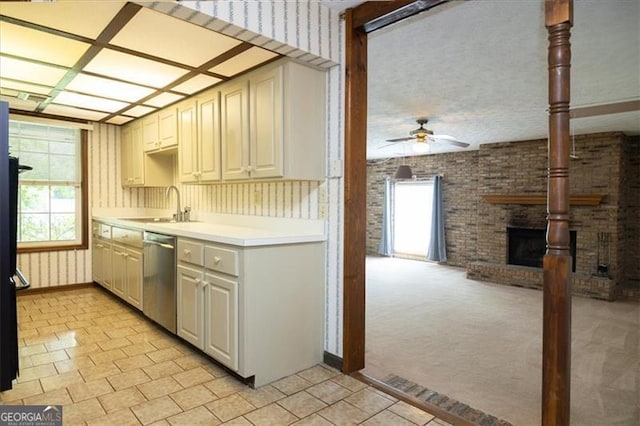 kitchen featuring brick wall, dishwasher, ceiling fan, sink, and light carpet