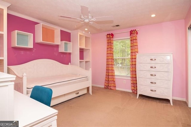 carpeted bedroom featuring ceiling fan and crown molding