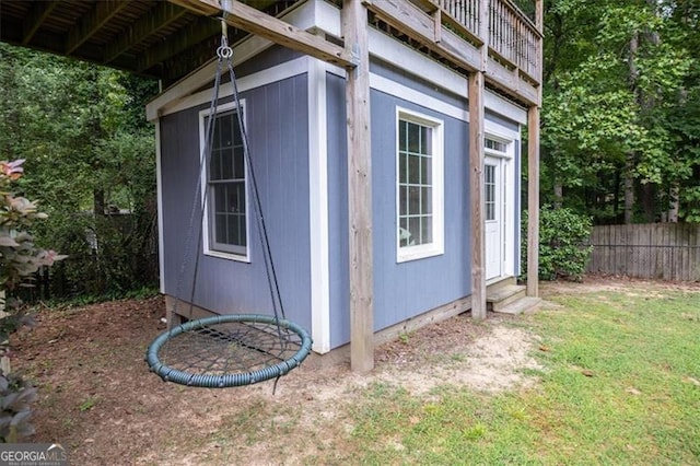 view of side of home featuring a yard and a balcony