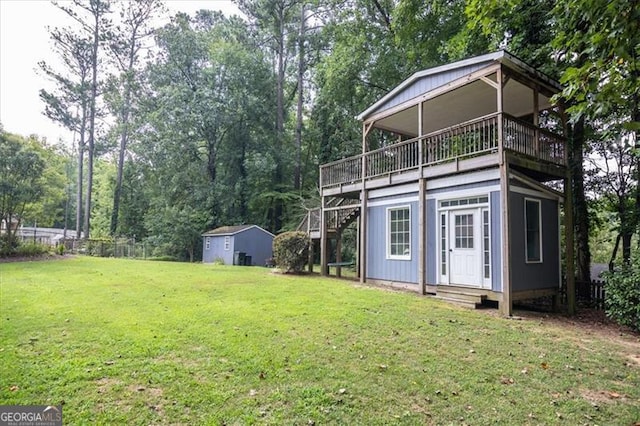 view of yard featuring a storage unit and a balcony