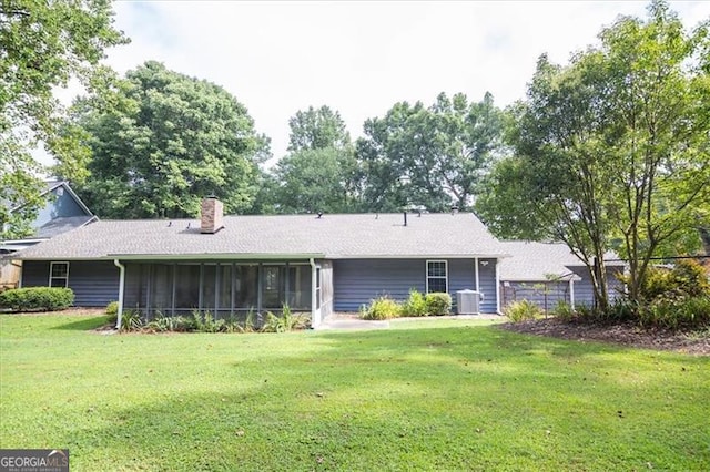 back of house with a lawn, central AC, and a sunroom