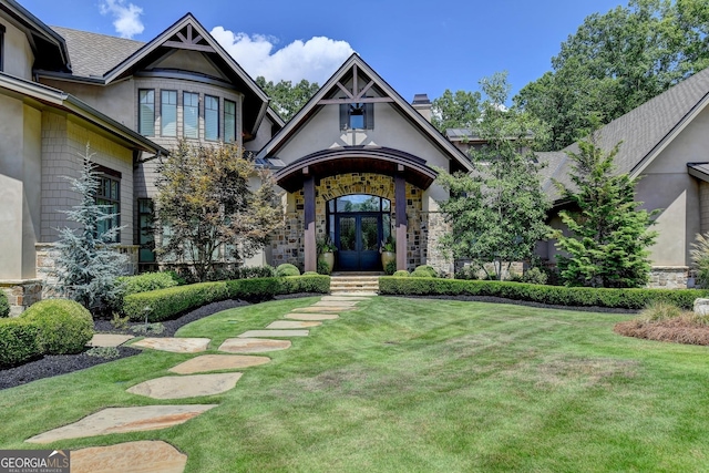 962 Chattooga Trce, Suwanee, GA 30024 - view of exterior entry featuring french doors, a lawn, stucco siding, and stone siding