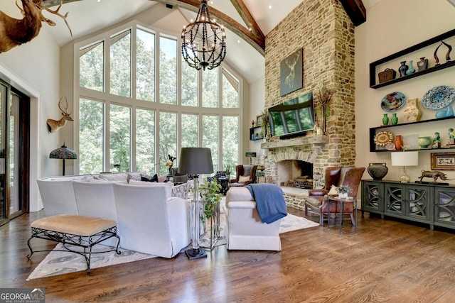 962 Chattooga Trce, Suwanee, GA 30024 - living room featuring high vaulted ceiling, a chandelier, beam ceiling, a fireplace, and wood finished floors