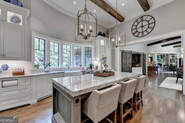 962 Chattooga Trce, Suwanee, GA 30024 - kitchen with high vaulted ceiling, beam ceiling, a chandelier, backsplash, and a center island