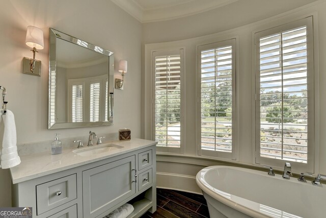 962 Chattooga Trce, Suwanee, GA 30024 - bathroom featuring crown molding, a freestanding tub, healthy amount of natural light, vanity, and wood finished floors